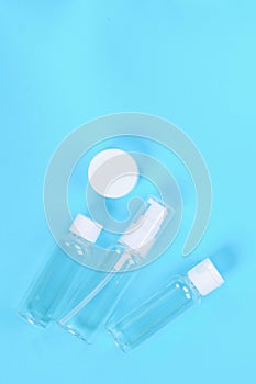 Set of empty small traveling cosmetics bottles on blue background. For soap, shampoo, shower gel