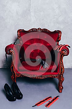 Set of erotic toys for BDSM on red chair photo