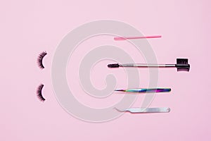 Set for eyelash extension on a pink background. Concept beauty beauty. False eyelashes, brush, applicator and tweezers