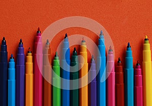 Set of felt tip pens on orange background, flat lay