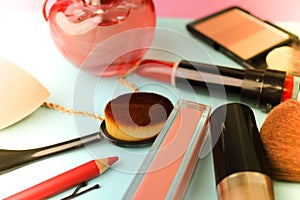 Set of female cosmetics from lipstick, highlighter, lip liner, brushes, brushes, perfume, powder, jewelry on a blue background