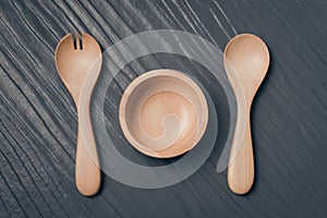 Set of fork, spoon and dish wood on black wooden table