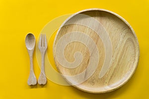 Set of fork,spoon and dish wood with yellow background