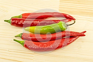 Set of four horizontal chili peppers red and green pod nea wooden background
