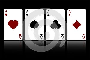 Set of four suits of playing cards with aces isolated on a black background with reflection