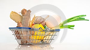 A set of Fresh vegetables in a cart from a supermarket on a white background, natural fresh tomatoes and cheese with chicken eggs