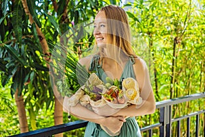 Set of fresh vegetables in a reusable bag in the hands of a young woman. Zero waste concept