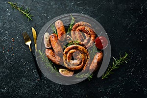 Set of fried barbecue sausages with rosemary and sauces.