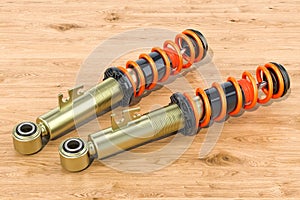 Set of front shock absorbers on the wooden table, 3D rendering