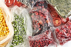 A set of frozen foods for the winter. Frozen berries, vegetables, corn, green peas, tomatoes in the freezer