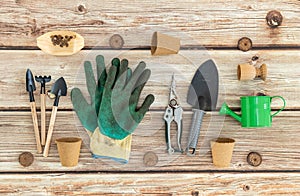 A set of gardening tools on a wooden table.