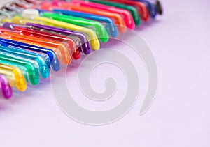 Set of gel pens of various colors with lilac background