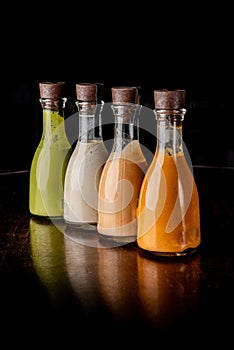 Set of glass bottles with different delicious craft sauces