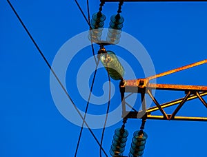 Set of Glass Electric insulators mounted on rusty power tower
