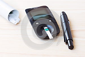 Set glucometer and syringe with Diabetes Indicator Strips For Blood Glucose Testing on wood background