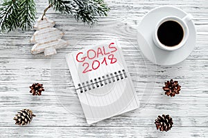 Set a goal for new year 2018. Notebook near cup of coffee on grey wooden background top view