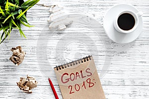 Set a goal for new year 2018. Notebook near pen and cup of coffee on grey wooden background top view copyspace