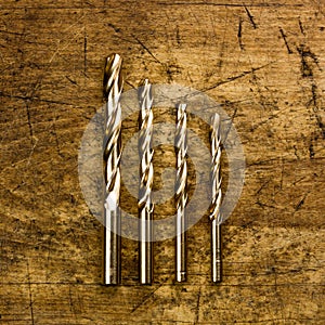 Set of golden drill bits on wooden background