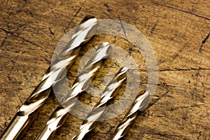 Set of golden drill bits on wooden background