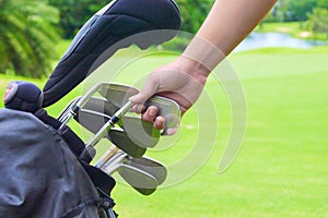 Set of golf clubs over green field background