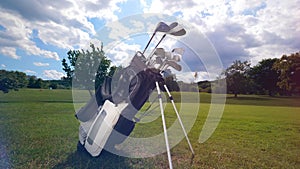 A set of golfing clubs on a field.