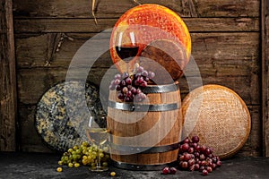 Set of grape, wine and various types of cheese on brown wooden background