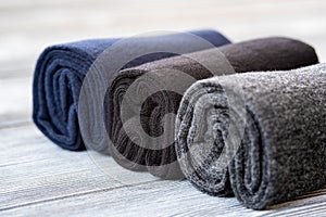 A set of gray, blue and black socks, rolled up for storage.
