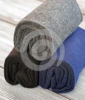 A set of gray, blue and black socks, rolled up for storage.