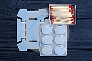 a set of gray metal portable burner packs with white dry alcohol fuel