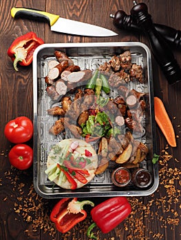 Set of grilled meat with vegetables on a tray