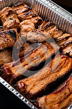 Set of grilled ribs and BBQ meat in a delivery box