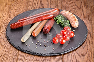 Set of grilled sausages on  slate plate