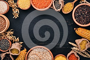 Set of Groats and Grains. Buckwheat, lentils, rice, millet, barley, corn, black rice. On a black background. photo