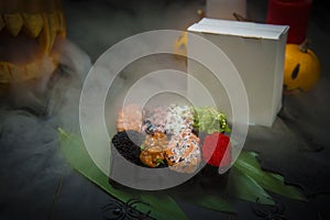 Set of Gunkan Sushi near Halloween decoration. pumpkin jack o lantern exhaling smoke photo