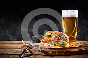 Set of hamburger beer and french fries. A standard set of drinks and food in the pub, beer and snacks. Dark background