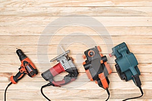 Set of hand carpentry power tools for woodworking lies on a light wooden background. Directly above