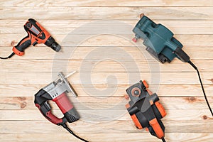 Set of hand carpentry power tools for woodworking lies on a light wooden background. Directly above