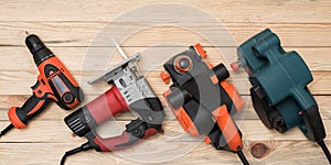 Set of hand carpentry power tools for woodworking lies on a light wooden background. Directly above