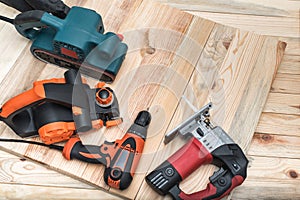 Set of handheld woodworking power tools for woodworking on light wooden background. Close up