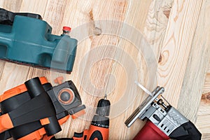 Set of handheld woodworking power tools for woodworking on light wooden background. Close up