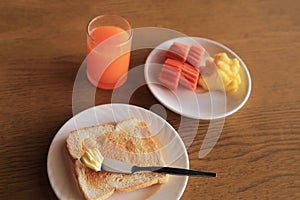 Set of healthy breakfast, plate of toast with butter and fresh fruits and orange juice