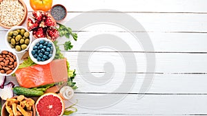 A set of healthy food. Fish, nuts, protein, berries, vegetables and fruits. On a white background. Top view.