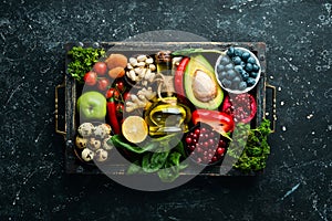 Set of healthy food in a wooden box: vegetables, fruits, fish, meat, nuts and herbs.