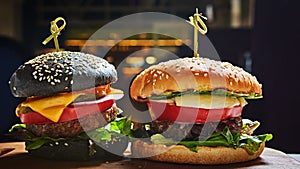 Set of homemade burgers in black and white buns with tomato, lettuce, cheese, onion on wood serving board over dark