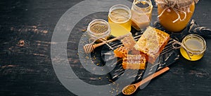 A set of honey and bee products. Honey in honeycomb. On a black wooden background. Free space for text