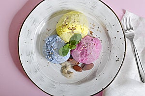 Set of ice cream scoops of different colors and flavours with berries, nuts and fruits