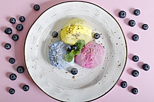 Set of ice cream scoops of different colors and flavours with berries, nuts and fruits