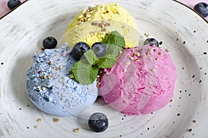 Set of ice cream scoops of different colors and flavours with berries, nuts and fruits