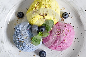 Set of ice cream scoops of different colors and flavours with berries, nuts and fruits