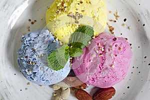 Set of ice cream scoops of different colors and flavours with berries, nuts and fruits